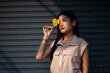 A young woman dressed in vintage clothes holds a yellow flower and admires it in her hand. and flowers to hide sight