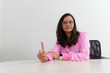 © Thales - Portrait of a psychopedagogue, wearing pink clothes, in her office, sitting, making a sign with her hand. Helps with school performance.