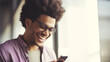 An young man with huge afro looking at the smartphone and laughing closeup.