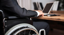A Person In A Wheelchair Using A Laptop
