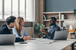 © gstockstudio - Three confident young people in formalwear discussing business during the meeting in the office