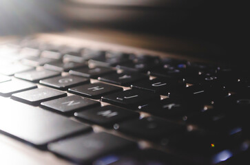 Laptop keyboard with light on table.