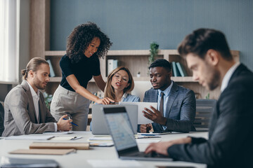 Canvas Print - Confident business team discussing strategy while having group meeting in the office together