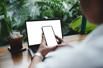 Wall Mural - A blank screen for hand typing text,using laptop and mobile phone contact business searching information in workplace on desk at office.