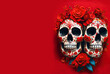 Two decorated skulls with red roses isolated on red background with copy space - conceptual illustration