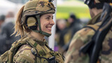 Fototapeta  - A smiling young lady with a helmet at a military expo