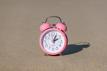 Alarm clock on the beach. Summer vacation concept.