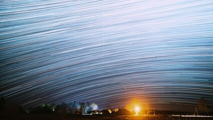 Wall Mural - Amazing Unusual Stars Effects. Bright Blue Colors. 4k Timelapse Night Starry Sky Above Village. Sky Background Over Rural Countryside Landscape. Meteors Cross Dark Blue Sky. Time Lapse, Time-lapse.