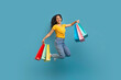© Prostock-studio - Excited young indian woman jumping with colorful shopping bags