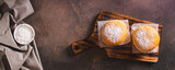 Fototapeta  - Fresh donuts with powdered sugar and sweet filling on a plate on the table top view web banner
