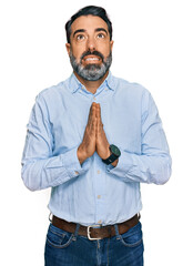 Sticker - Middle aged man with beard wearing business shirt begging and praying with hands together with hope expression on face very emotional and worried. begging.