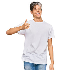 Wall Mural - Young hispanic man wearing casual white tshirt smiling happy and positive, thumb up doing excellent and approval sign