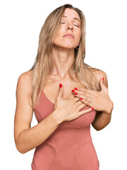 Wall Mural - Beautiful caucasian woman wearing casual clothes smiling with hands on chest with closed eyes and grateful gesture on face. health concept.