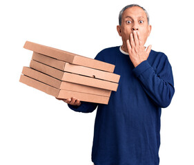 Canvas Print - Senior handsome man holding pizza boxes covering mouth with hand, shocked and afraid for mistake. surprised expression