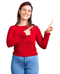 Wall Mural - Young beautiful woman wearing casual clothes smiling and looking at the camera pointing with two hands and fingers to the side.