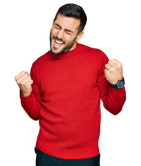 Canvas Print - Young hispanic man wearing casual clothes very happy and excited doing winner gesture with arms raised, smiling and screaming for success. celebration concept.