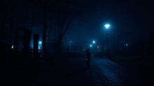 Small Kid Wearing Warm Clothes Walks By The Dark Alley At Night. Baby Holding A Book Stops Looking At Camera.