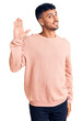 © Krakenimages.com - Young hispanic man wearing casual clothes waiving saying hello happy and smiling, friendly welcome gesture