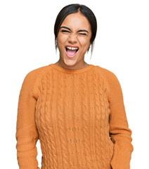 Wall Mural - Young brunette woman wearing casual winter sweater winking looking at the camera with sexy expression, cheerful and happy face.