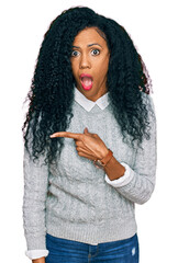 Wall Mural - Middle age african american woman wearing casual clothes surprised pointing with finger to the side, open mouth amazed expression.