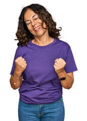 Sticker - Middle age hispanic woman wearing casual clothes very happy and excited doing winner gesture with arms raised, smiling and screaming for success. celebration concept.