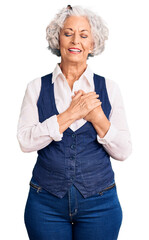 Wall Mural - Senior grey-haired woman wearing casual clothes smiling with hands on chest with closed eyes and grateful gesture on face. health concept.