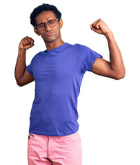 Wall Mural - African handsome man wearing casual clothes and glasses showing arms muscles smiling proud. fitness concept.