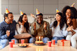 © Prostock-studio - Happy multiracial students celebrating birthday of black guy in kitchen