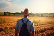 © KirKam - Farmer Gazing Over Golden Wheat Field at Sunset