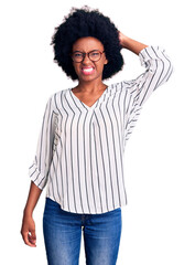 Sticker - Young african american woman wearing casual clothes and glasses confuse and wonder about question. uncertain with doubt, thinking with hand on head. pensive concept.