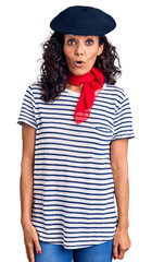 Poster - Middle age beautiful woman wearing french beret and scarf scared and amazed with open mouth for surprise, disbelief face