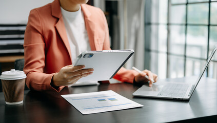 business documents on office table with smart phone and digital tablet and graph financial and woman working .