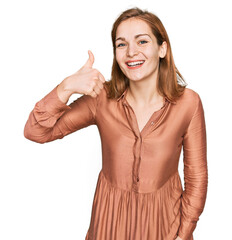 Wall Mural - Young caucasian woman wearing sexy party dress smiling happy and positive, thumb up doing excellent and approval sign