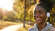 Close up happy candid young black african american female teenager running jogging outdoors in nature 