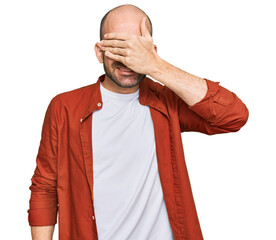 Sticker - Young hispanic man wearing casual clothes smiling and laughing with hand on face covering eyes for surprise. blind concept.