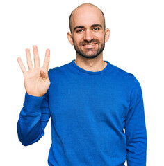 Canvas Print - Young hispanic man wearing casual clothes showing and pointing up with fingers number four while smiling confident and happy.