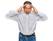 © Krakenimages.com - Middle age indian man wearing casual white shirt suffering from headache desperate and stressed because pain and migraine. hands on head.