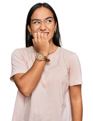Wall Mural - Young asian woman wearing casual clothes looking stressed and nervous with hands on mouth biting nails. anxiety problem.