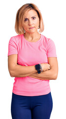 Canvas Print - Young blonde woman wearing sportswear skeptic and nervous, disapproving expression on face with crossed arms. negative person.