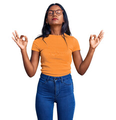 Young indian girl wearing casual clothes and glasses relax and smiling with eyes closed doing meditation gesture with fingers. yoga concept.