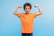 © Prostock-studio - Strong, confident boy flexing muscles on blue background