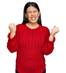 Poster - Beautiful brunette woman wearing casual sweater very happy and excited doing winner gesture with arms raised, smiling and screaming for success. celebration concept.