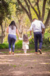 © natrocfort - Family members holding hands and walking backwards in a park together family