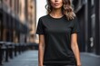 Young athletic woman wearing black blank mockup tshirt on a blurred urban background
