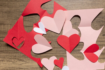 flat lay red and pink paper valentine's cut outs against wood