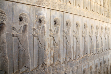 Wall Mural - Ancient wall with bas-relief with assyrian warriors with spears, Persepolis, Iran.