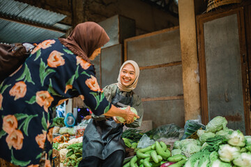 Wall Mural - happy asian green grocery seller helping her customer choosing vegetable