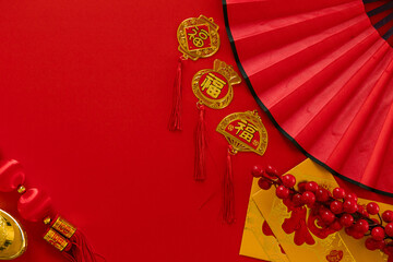 Wall Mural - Chinese New Year  festival decorations, golden, flowers, paper fan, Chinese lanterns, envelopes on red background. Flat lay, top view, Text space images