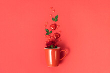 Valentine's day concept. Red cup with roses, chocolate and red hearts on red background