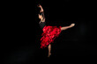 © Westend61 - Flamenco student dancing with arms raised against black background